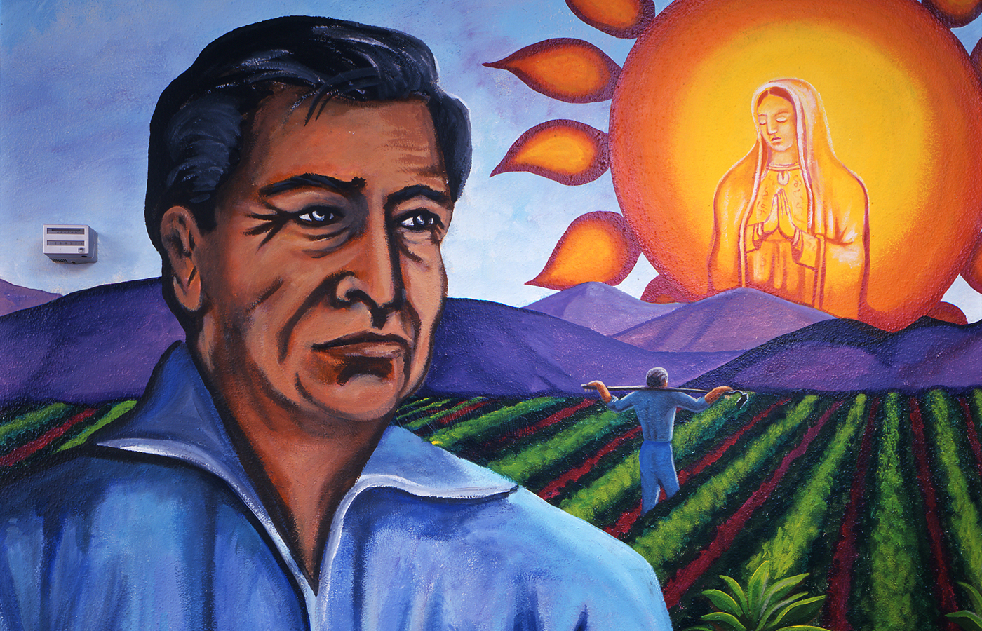 Martin Moreno Mural man in front of farm, religious iconography in sun